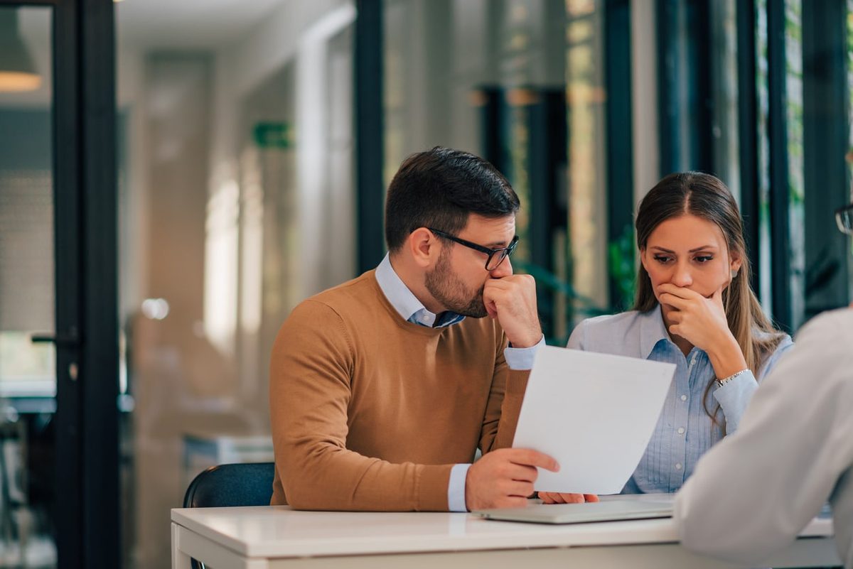 Two people looking over a document at a desk with concern