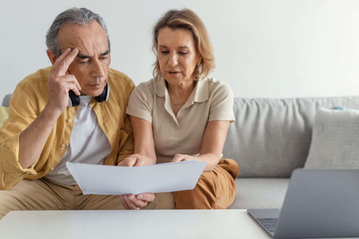 An older couple reading a document together at home